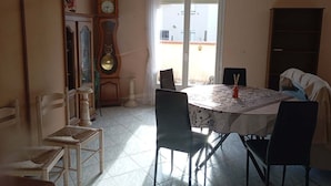 Ein Essbereich mit einem runden Tisch, Stühlen, einer Uhr und Blick durch eine Glastür.