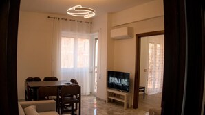 Un soggiorno con zona pranzo, televisore e lampadario.