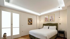A bedroom with a large bed, a skylight, a dog statue, and artwork on the walls. - MZ Kolonaki (Athina)