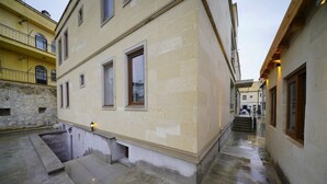 A narrow alleyway with a building featuring a stone facade and multiple windows. - nirvana cave house hotel (Nevsehir)