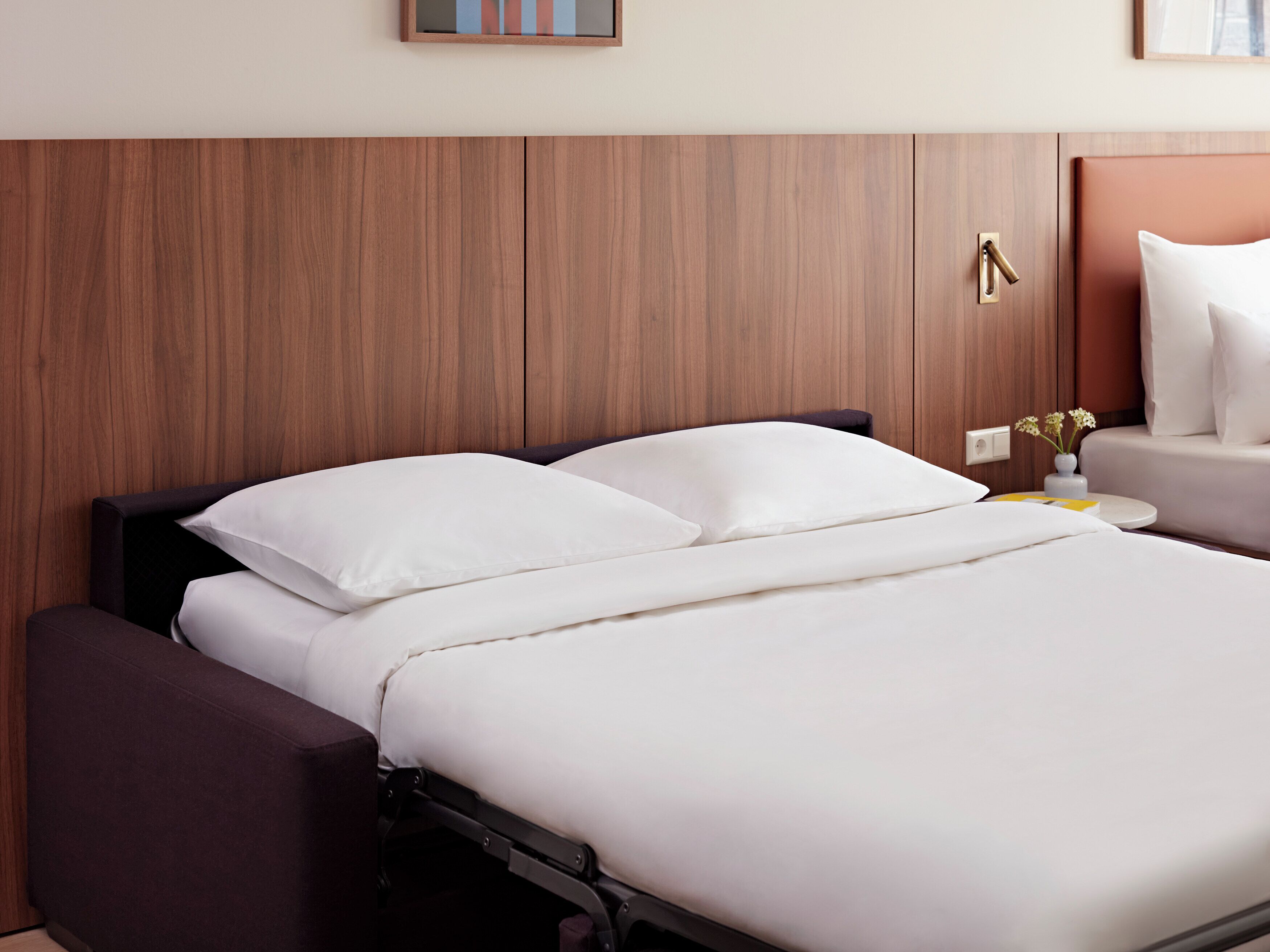 Une chambre d’hôtel avec un lit, une table de chevet et une petite table d’appoint.