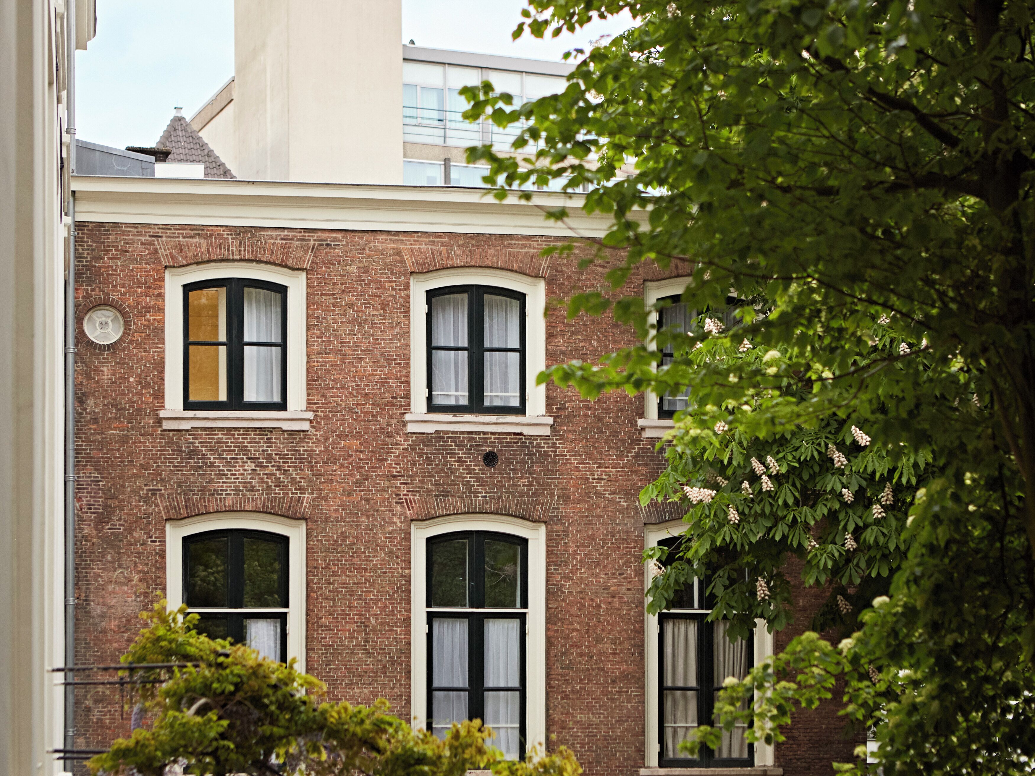 A brick building with multiple windows and a visible door.