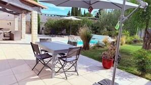An outdoor patio with a table and chairs, a pool, and a garden. - Le Clos du Cornier - Peace & quiet & private pool (Barjac)