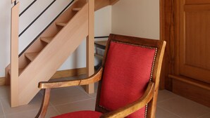 A wooden staircase with a red cushioned chair at the bottom. - Renovated farmhouse in the heart of nature in the PNR de Millevaches en Limousin (Sussac)