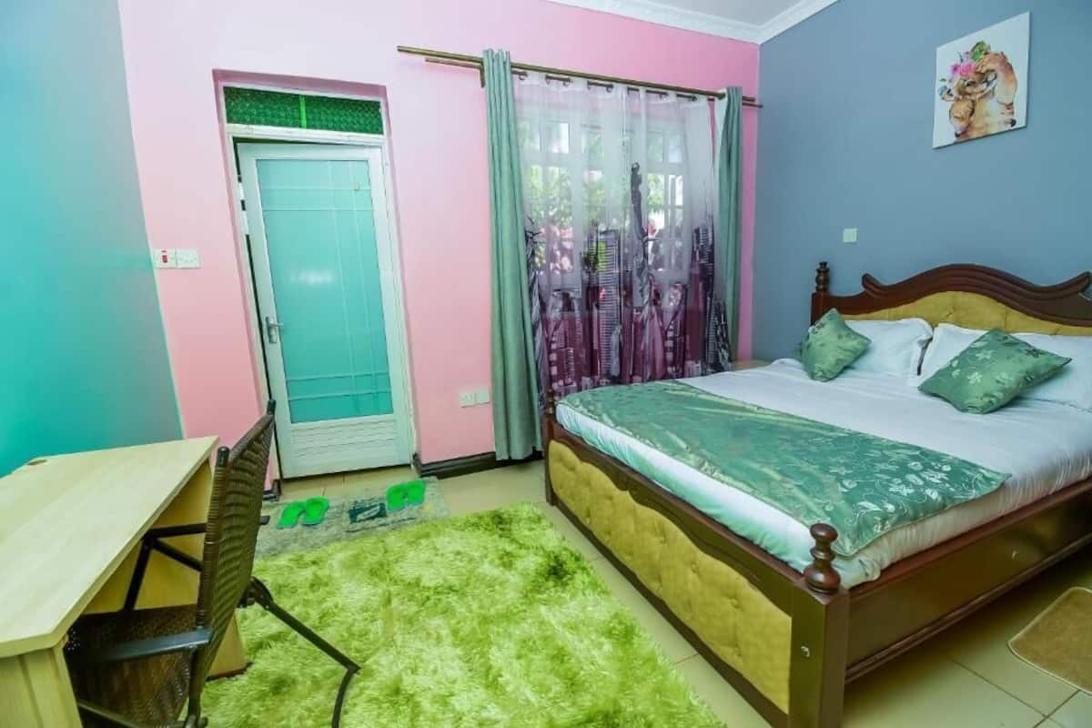 Un dormitorio con cama, escritorio y puerta.