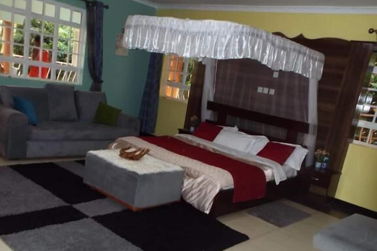 Un dormitorio con cama, sofá y ventana.