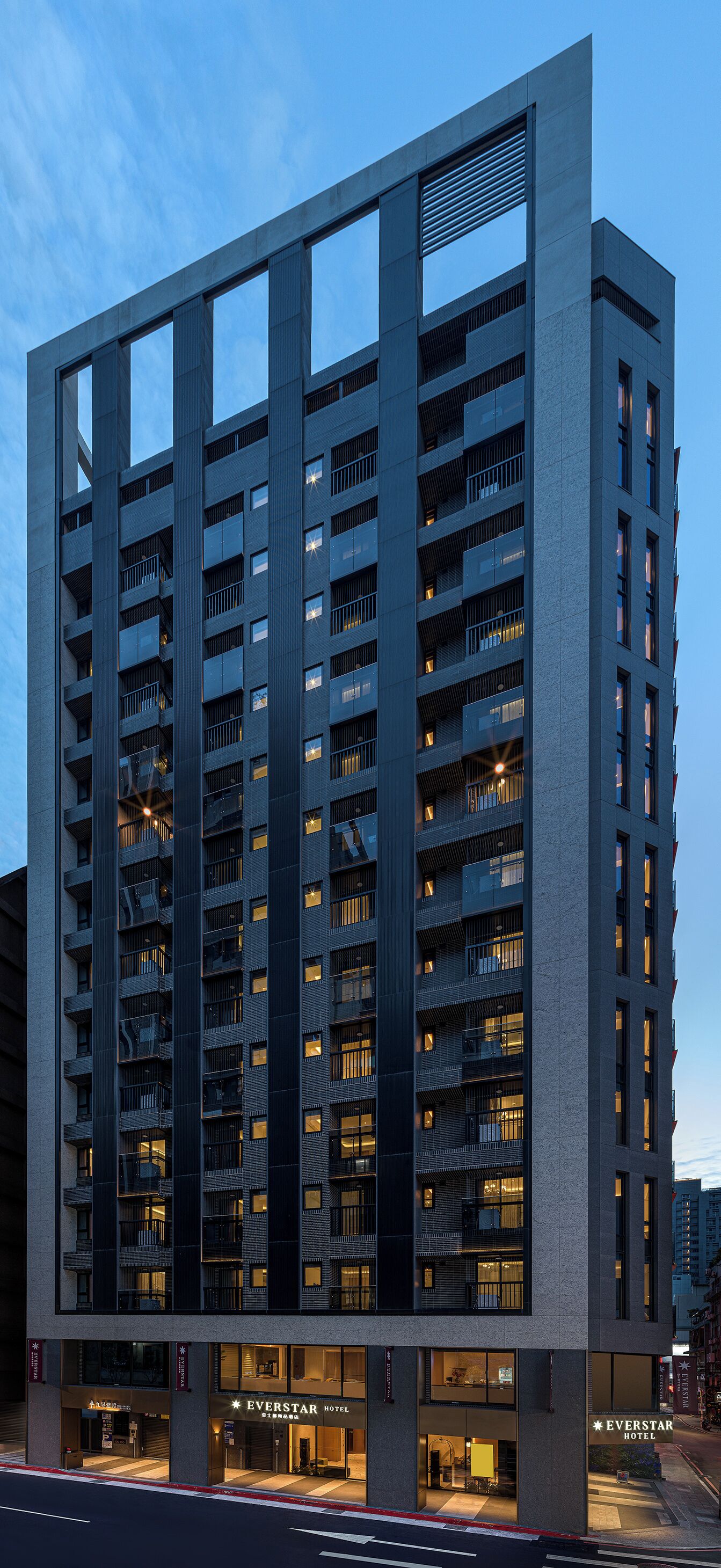 Un hôtel à plusieurs étages au design moderne, doté de balcons et d’une entrée imposante.