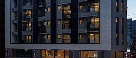 Un hôtel à plusieurs étages au design moderne, doté de balcons et d’une entrée imposante.