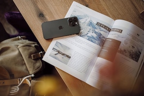 Un livre intitulé « 12 Peaks Trophy » et un smartphone posés sur une surface en bois.
