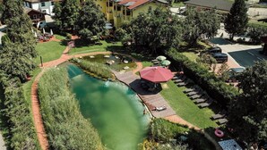 Un quartier résidentiel doté d’une piscine, de chaises longues et d’un parasol rouge.