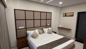 Ein modernes Schlafzimmer mit einem großen Bett, Nachttischen, einer Kopfteil und einem an der Wand befestigten Regal sowie einer Tür.