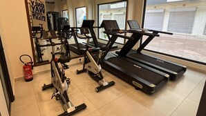 Ein Fitnessraum mit Laufbändern, Crosstrainern und Heimtrainern.