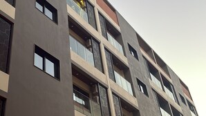 Ein mehrstöckiges Gebäude mit modernem architektonischen Design, das Balkone und Fenster kombiniert.