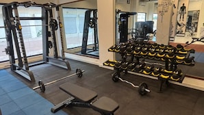 Ein Fitnessraum mit Gewichthebequipment, einer Bank und einer Hantelbank.