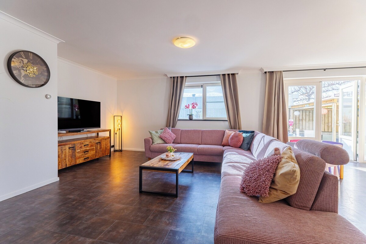 A living room with a sofa, a coffee table, a TV, and a wooden cabinet.