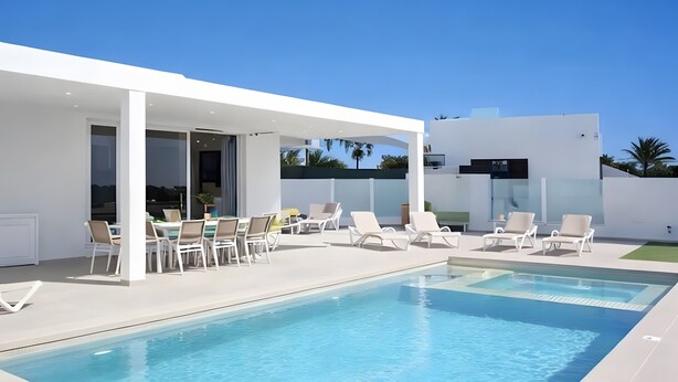 A modern outdoor pool area with lounge chairs and a covered seating area. - Vacation Villa 'Villa Esmerad' with Mountain Views, Wi-Fi and Air Conditioning (Playa Blanca)