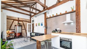 A modern kitchen with a wooden table, white cabinets, and a built-in oven. - Elegant and bright apartment in the center (Granada)