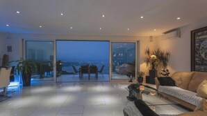 A modern living room with a glass door leading to a balcony with a city view. - Villa Diamond in Opatija - Crovillas (Opatija)