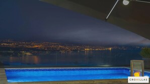 A nighttime view of a swimming pool with a cityscape in the background. - Villa Diamond in Opatija - Crovillas (Opatija)