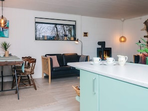 Un espace de vie chaleureux comprenant un canapé, une table à manger et un comptoir de cuisine.
