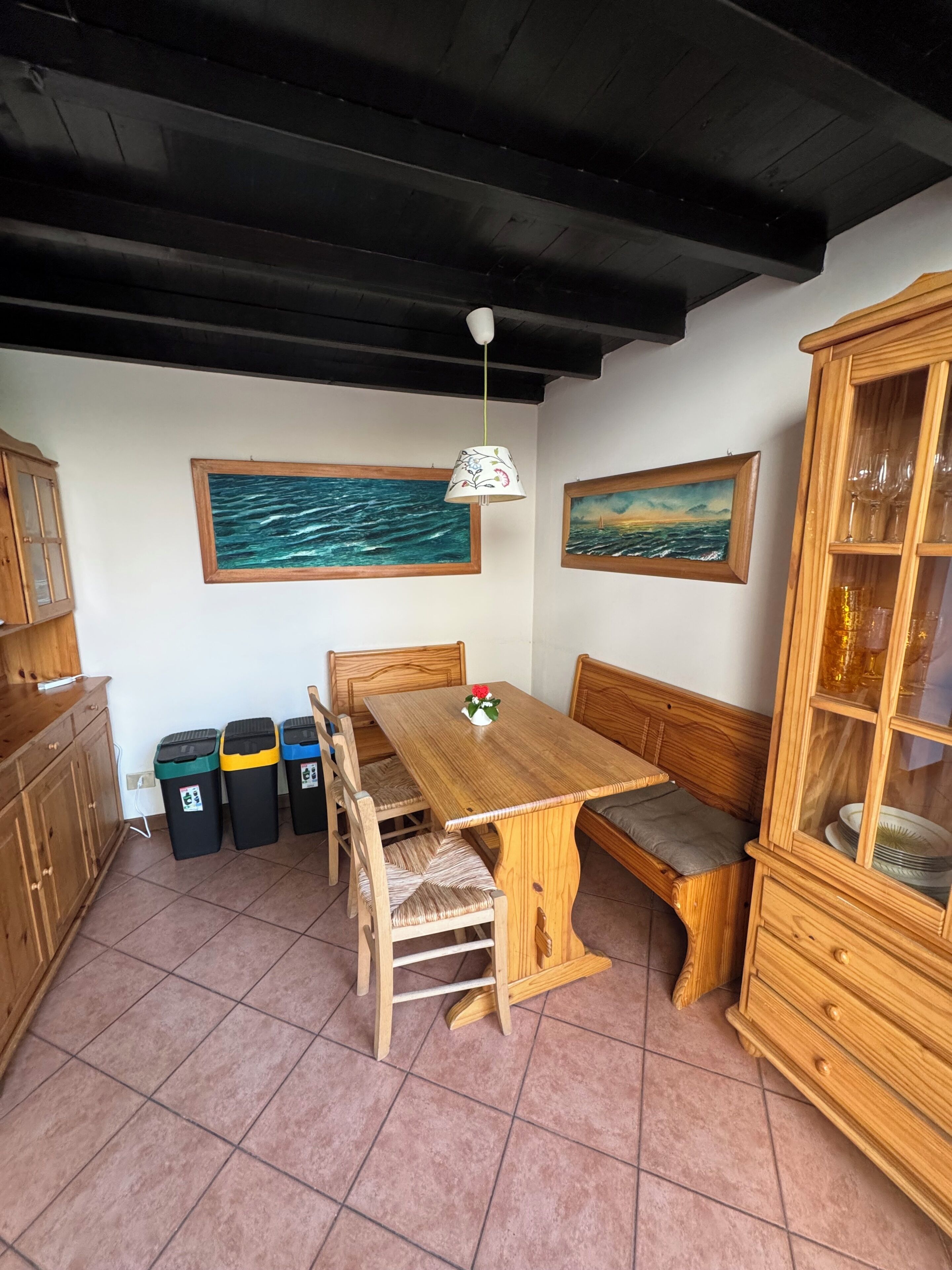 Ein Essbereich mit einem Holztisch, Bänken und einem Schrank.