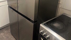 Ein Edelstahl-Kühlschrank und Herd in einer Küche.