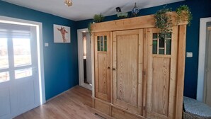 A room with a wooden wardrobe, a giraffe painting, and a hanging light fixture. - Boutique Farm Stay: Friendly Dogs & Family-Friendly Farm Meals. Optional Extras. (Kovachevets)
