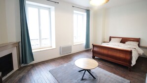 Un dormitorio con una cama de madera, una mesa redonda y una chimenea.