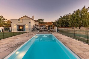 A modern house with a swimming pool, a covered outdoor seating area, and a well-maintained garden. - Marlborough Estate: Pool, Spa, Tennis & Pizza Oven (Riverlands)