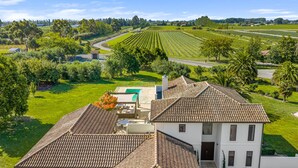 Una villa con techo de tejas, piscina y un jardín bien cuidado.
