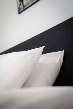A bed with white pillows and a dark headboard. - Hotel am Hafen Leverkusen (Leverkusen)