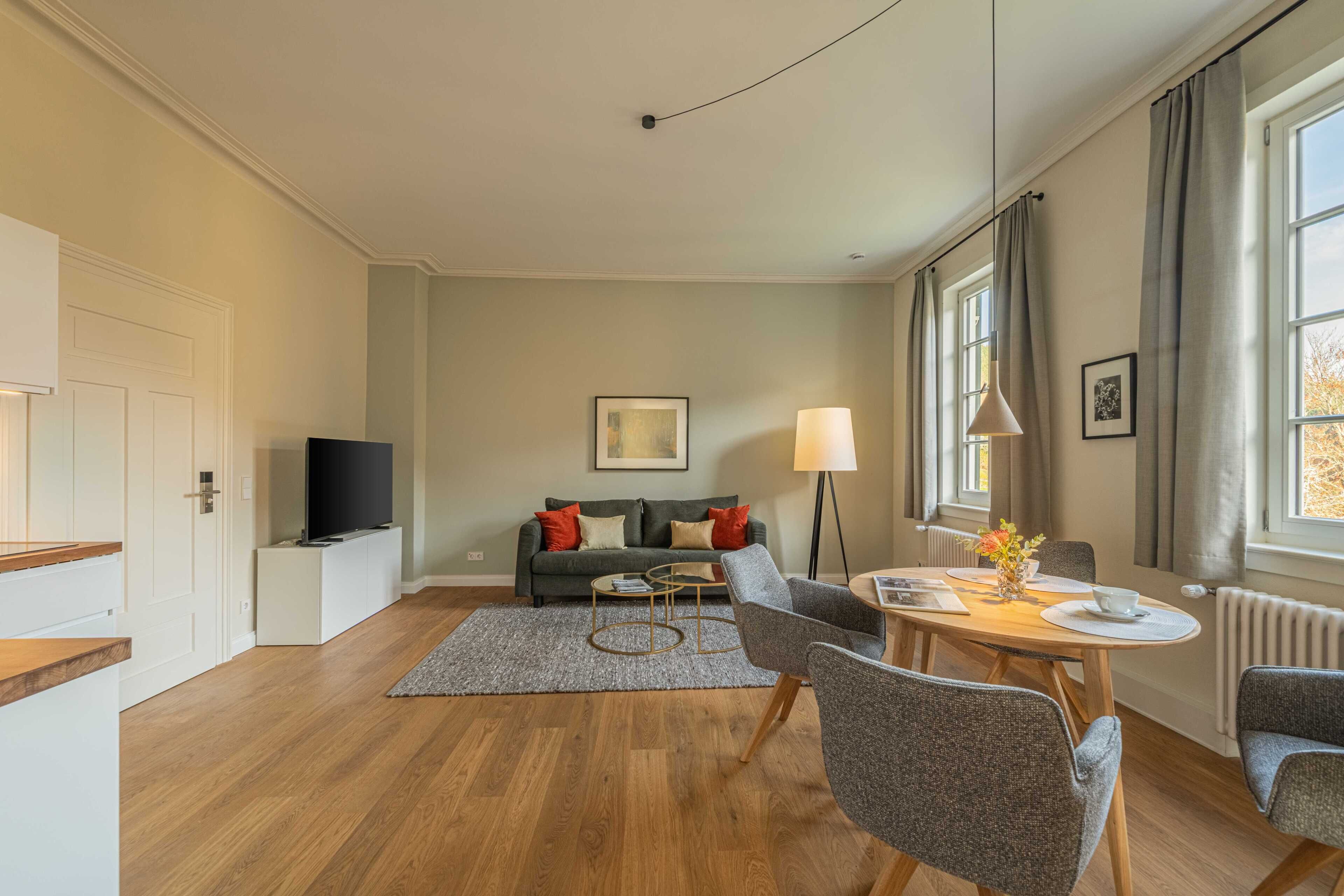 A modern living room with a sofa, coffee table, and dining area.