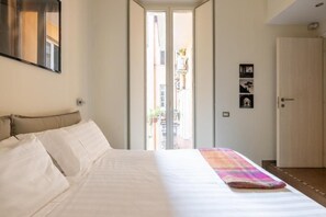 Ein Schlafzimmer mit Bett, einer Tür und Blick ins Freie.