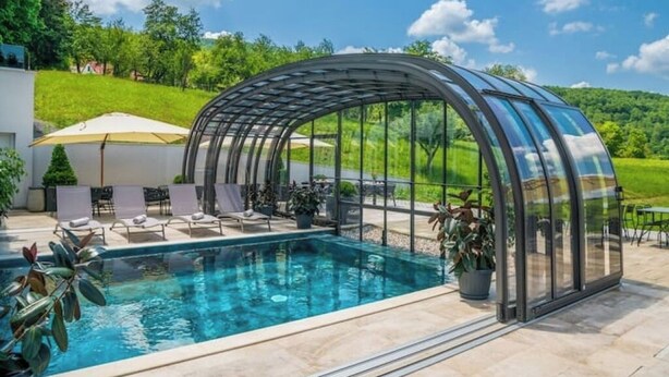 A glass-enclosed pool area with lounge chairs and a pergola. - Relax in Style: Comfort Room with Private Jacuzzi at Resort Stribor (Severin na Kupi)