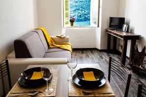 Apartamento panorâmico, vista para o lago | Área de estar | TV de tela plana 32 polegadas com canais digitais