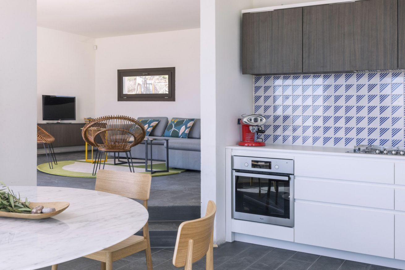 A compact living space with a dining area, kitchen, and seating area.