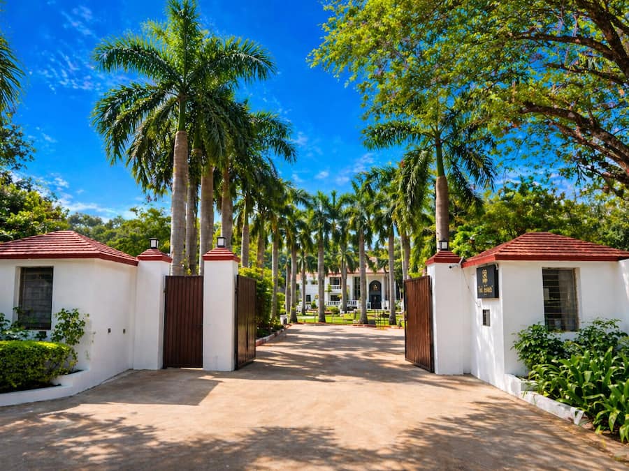 A pathway flanked by white buildings with red roofs, leading to a building with a sign reading 'The Bar.'