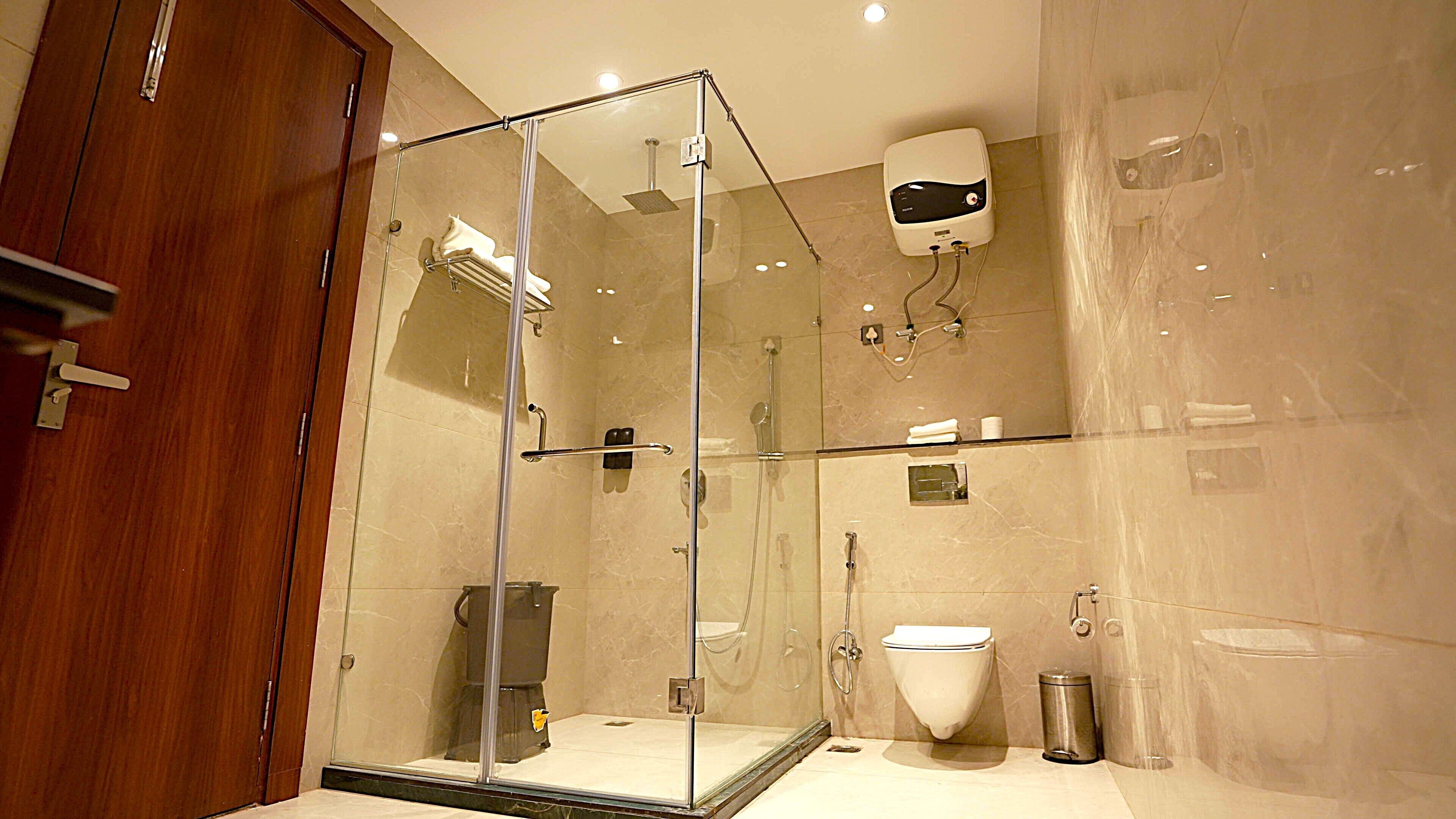 Une salle de bain moderne avec une douche à parois de verre, des toilettes et un lavabo.