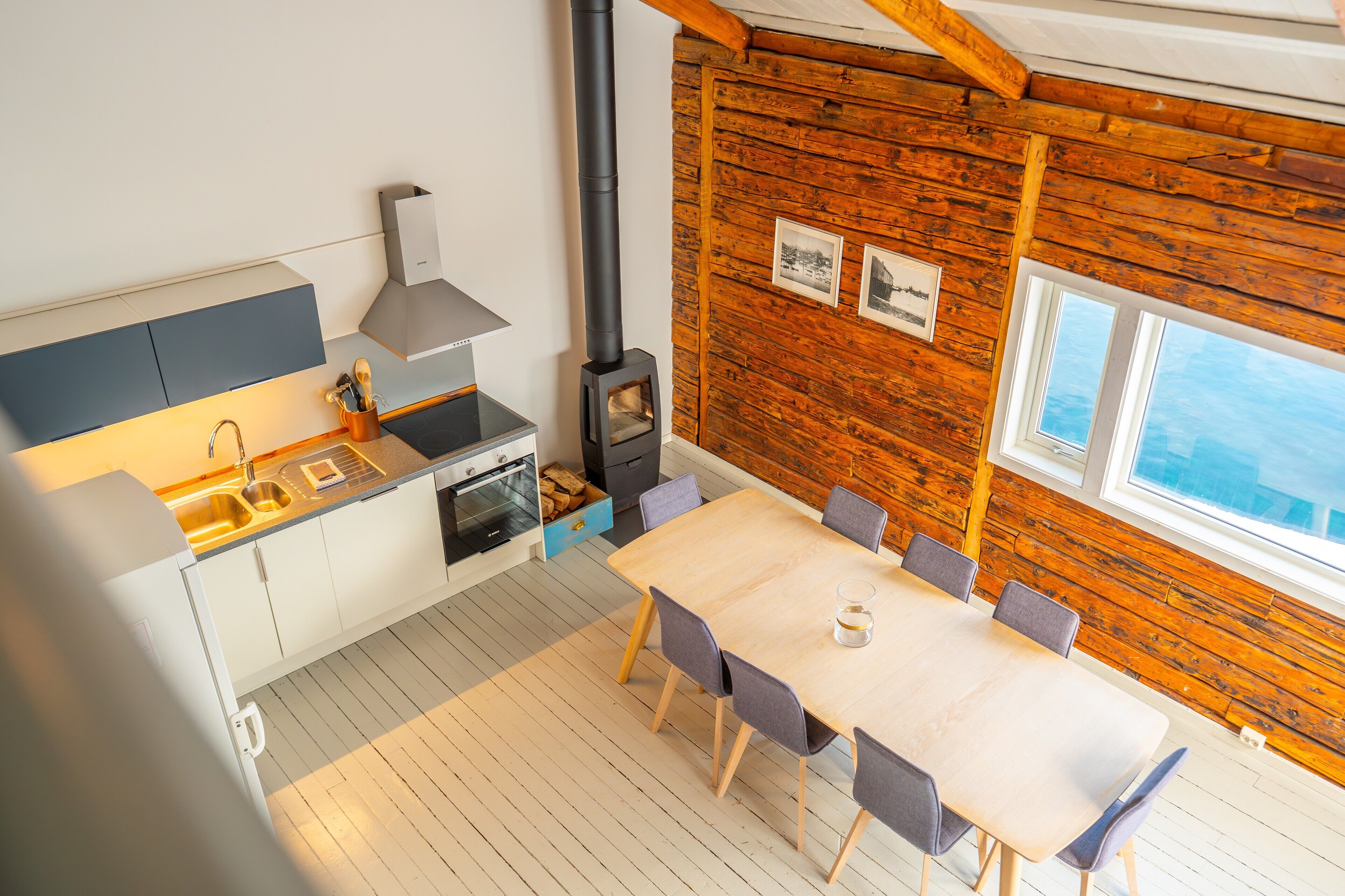 A modern kitchen with a stove, sink, and dining area.