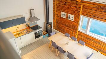 A modern kitchen with a stove, sink, and dining area.
