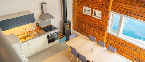 A modern kitchen with a stove, sink, and dining area.