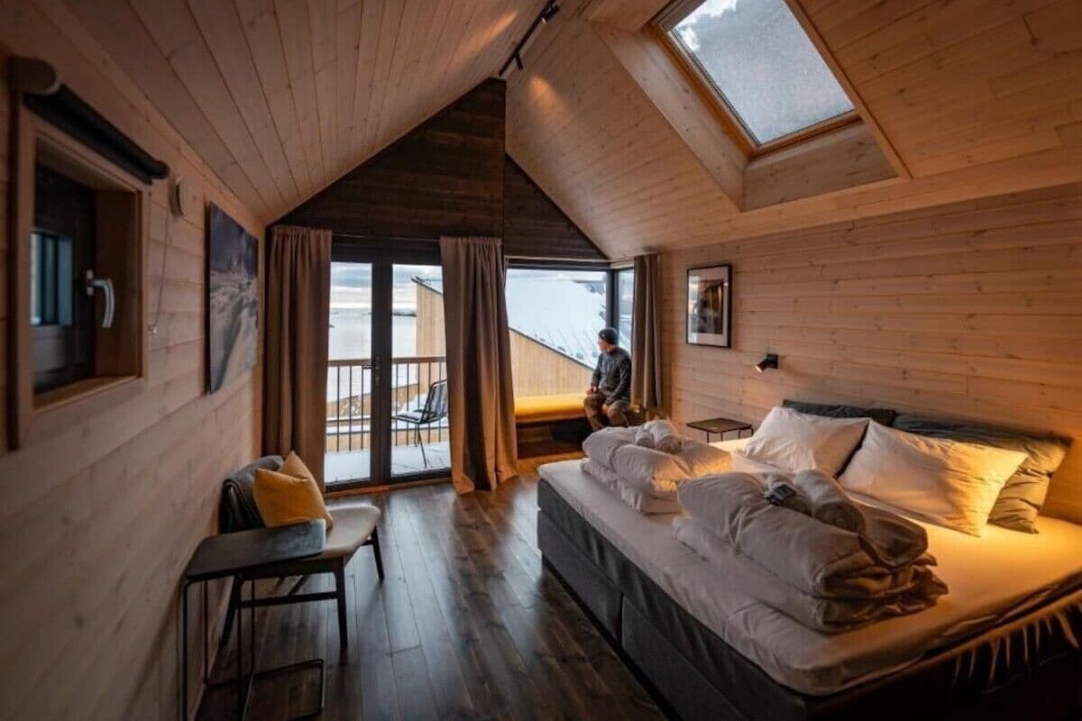Una habitación acogedora con una cama, un escritorio y vistas por una ventana grande.