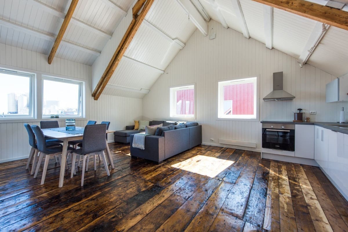 A loft-style room with a dining area, seating, and a kitchenette.