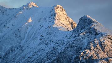 Una montagna innevata con terreno impervio e affioramenti rocciosi.