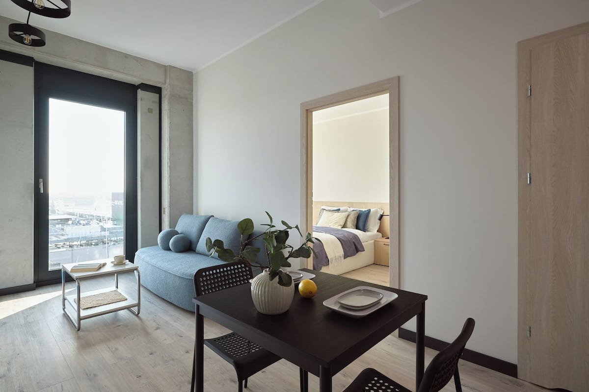 Un espace de vie moderne comprenant un canapé, une table à manger et une vue sur la ville.