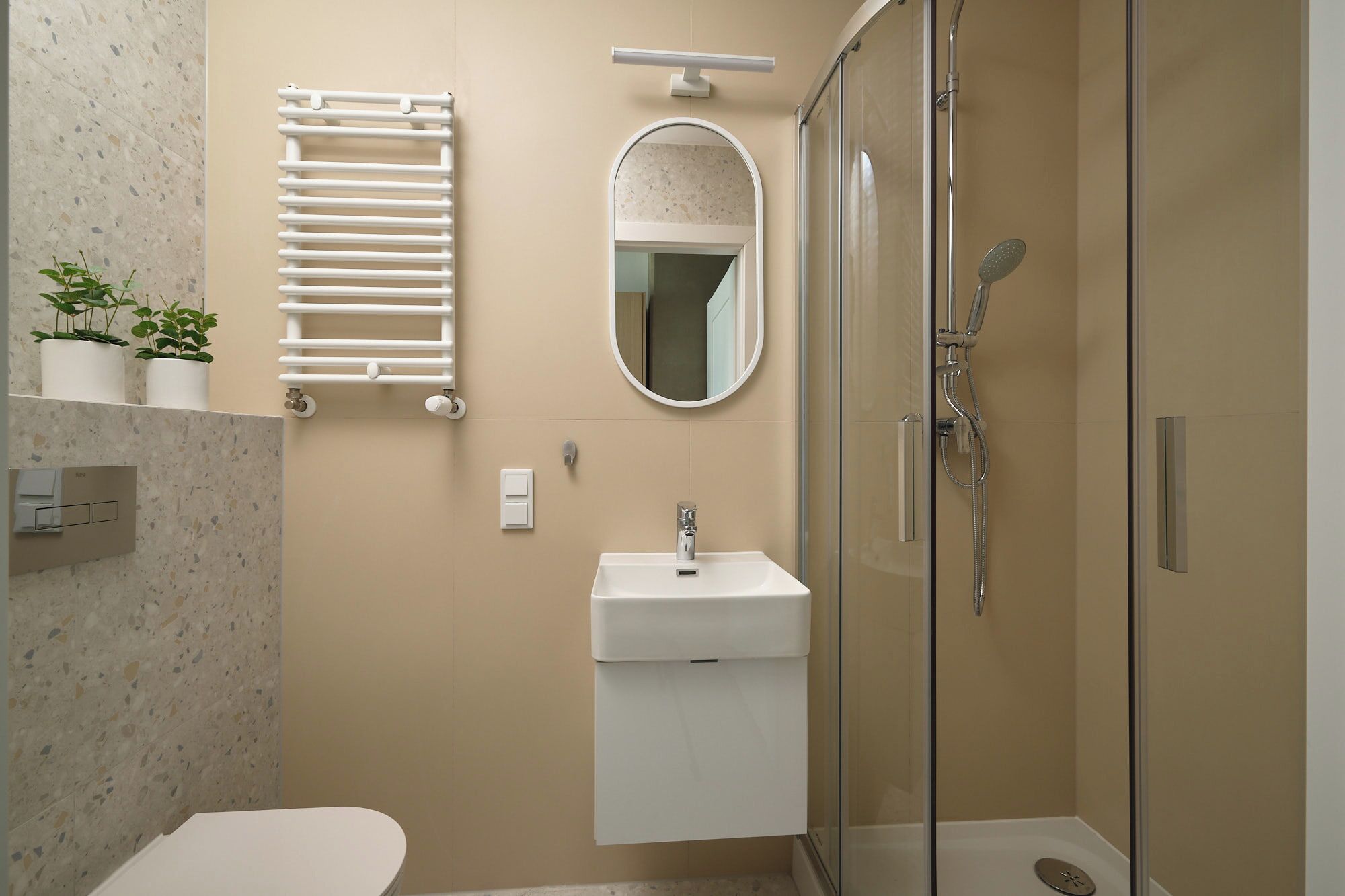 Een badkamer met toilet, wastafel, spiegel, handdoekhouder en douche.