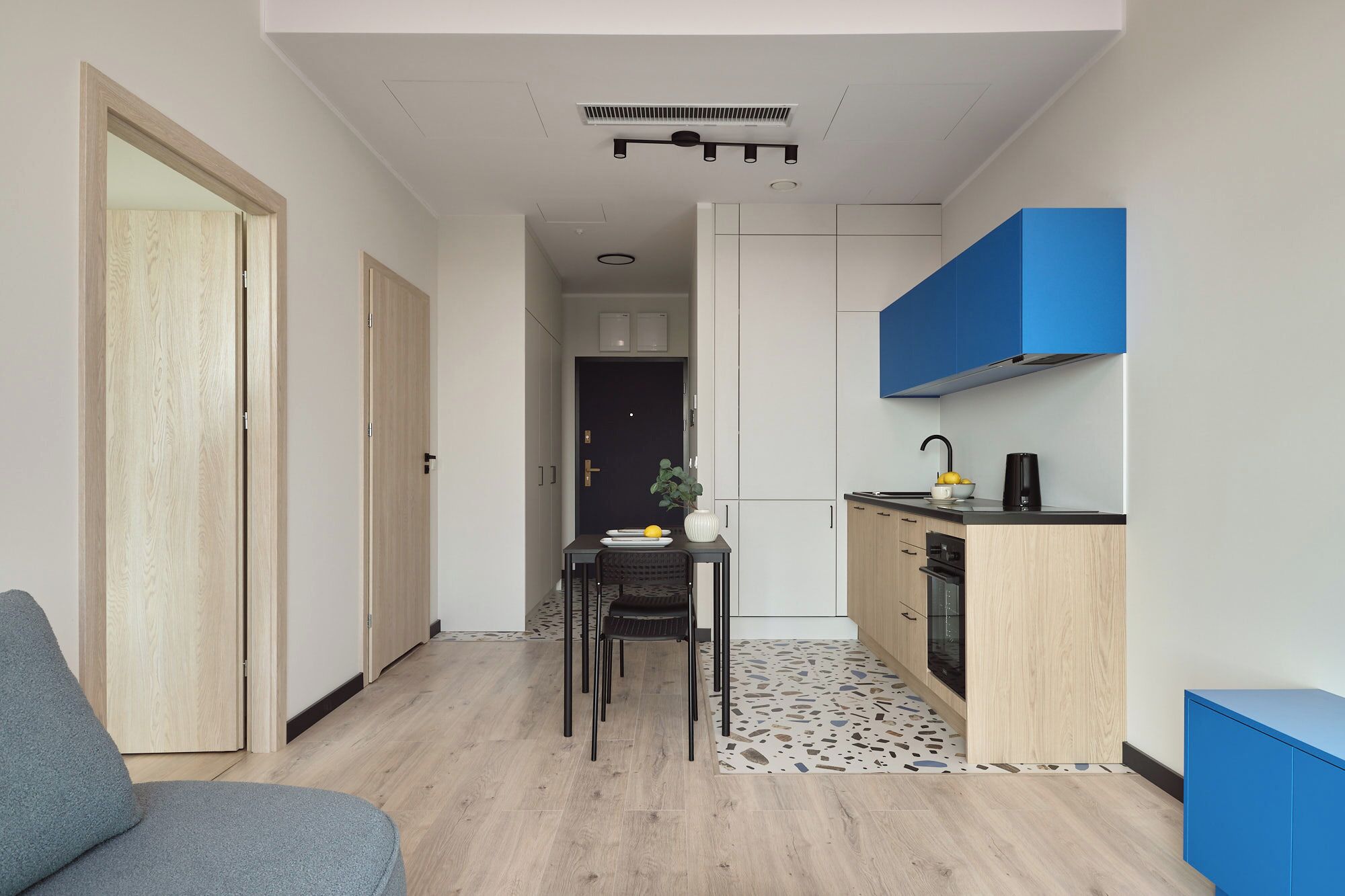 Un espacio habitable compacto con kitchenette, comedor y una zona de estar separada.