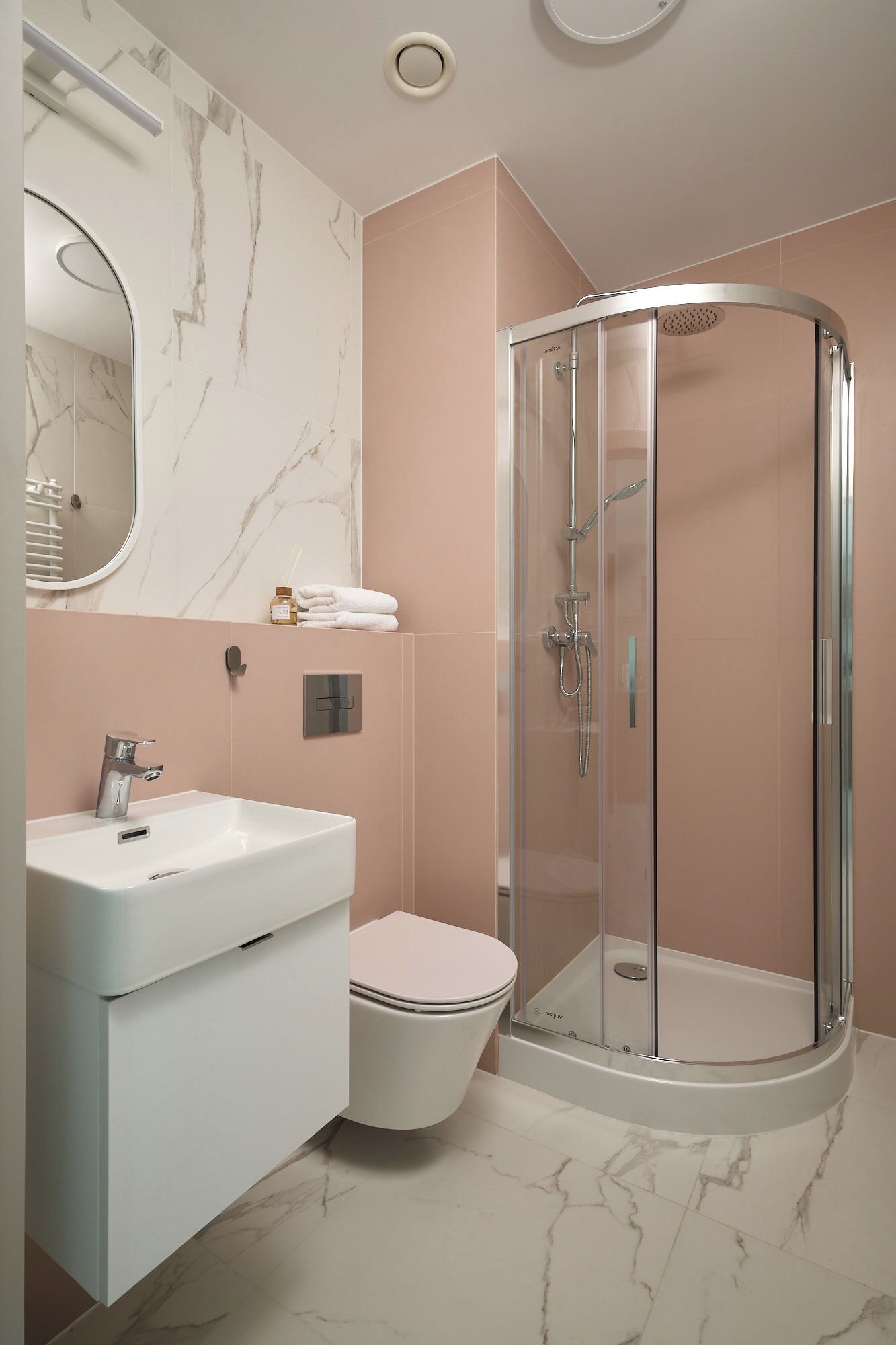 Ein modernes Badezimmer mit einem weißen Waschbecken, einer Toilette und einer Duschkabine.