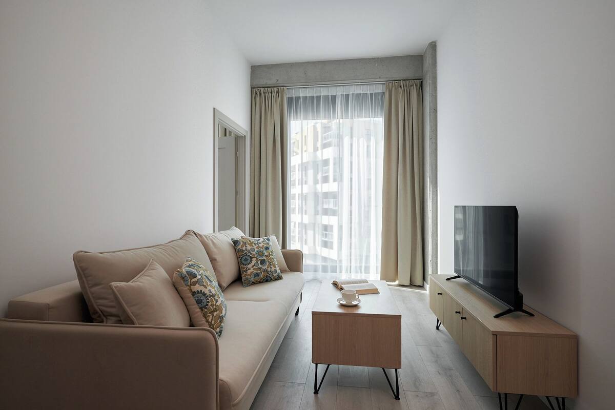 Un salon moderne avec un canapé, une table basse et un meuble pour la télévision.