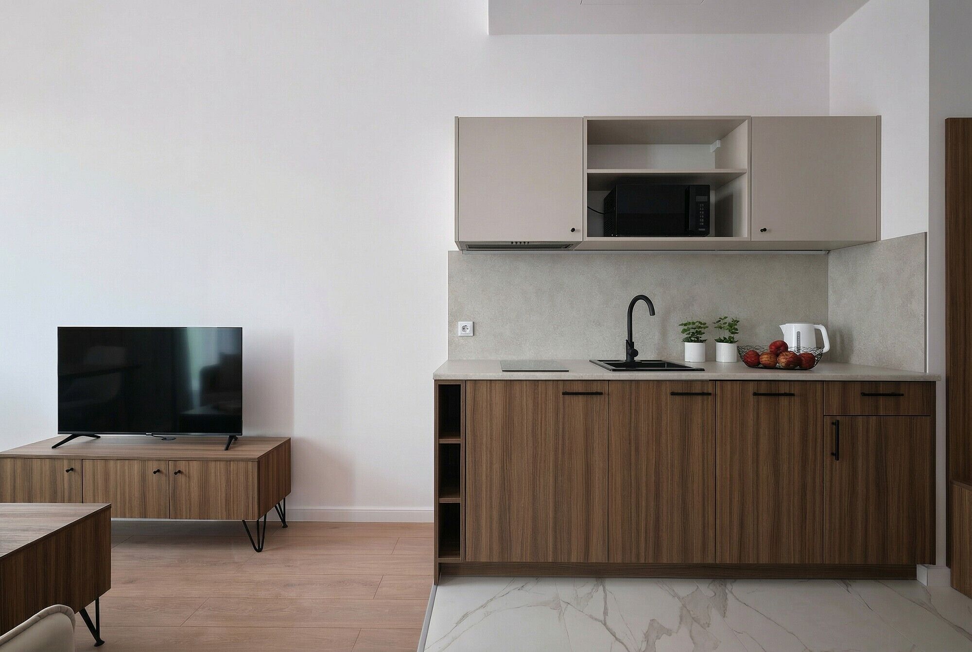 Une cuisine moderne avec des meubles en bois, un four à micro-ondes encastré et un évier.
